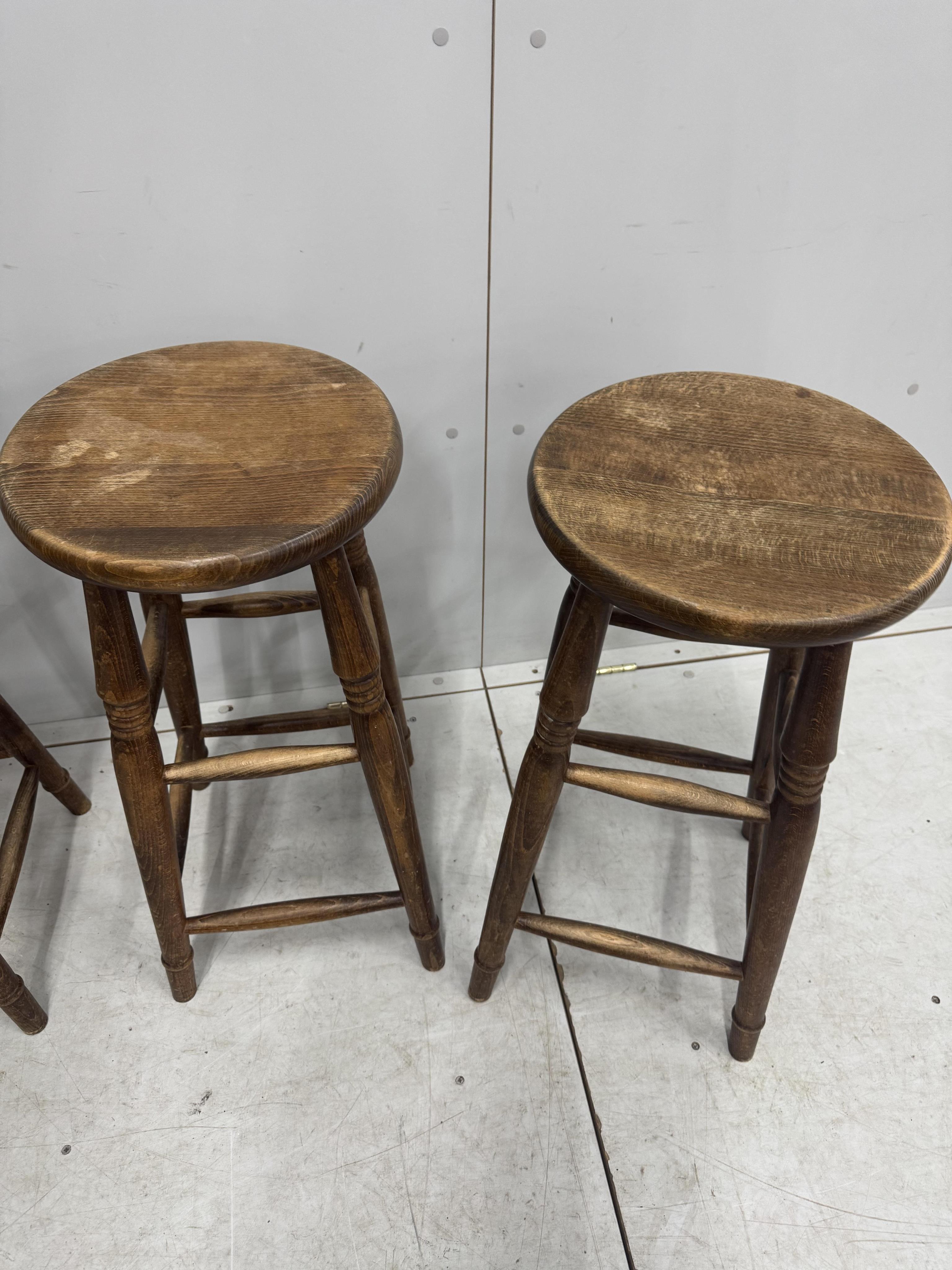 A set of four vintage beech bar stools, diameter 33cm, height 69cm. Condition - fair